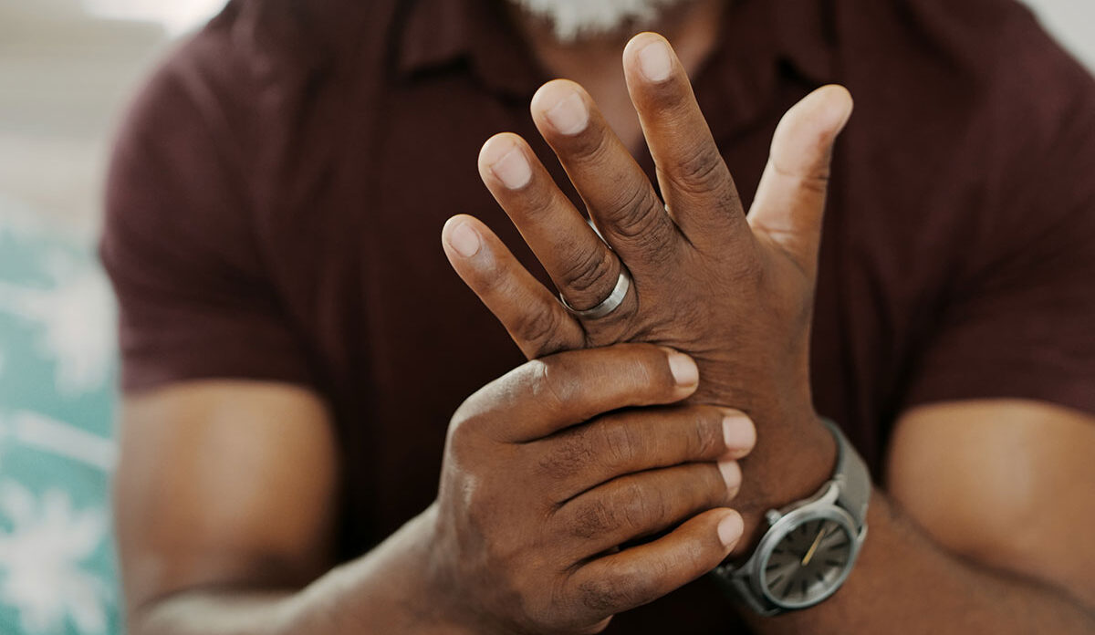 man holding hand with osteoarthritis in pain