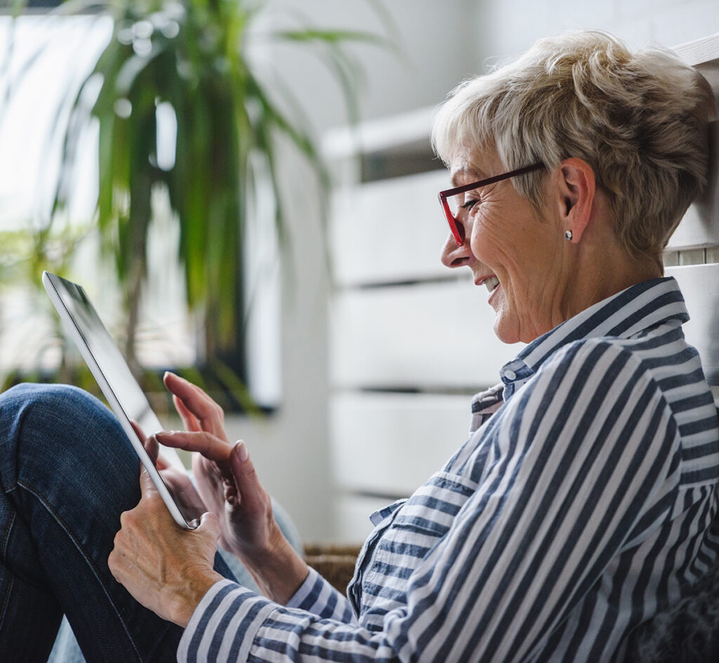 Senior woman using digital tablet at home